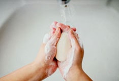 Hands being washed with soap and window.